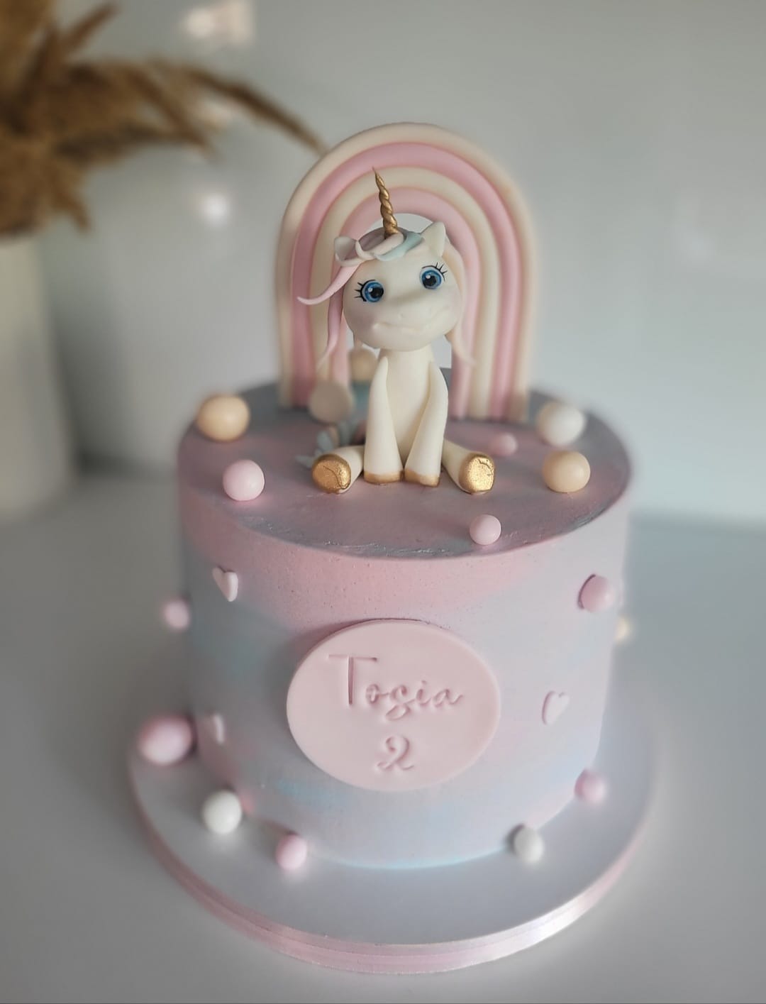 Tort z jednorożcem i tęczą w pastelowych kolorach